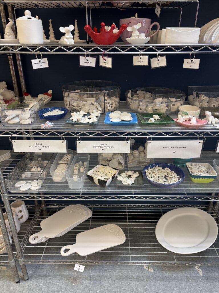 The paint your own pottery pieces have hanging tags on the shelves under each piece that indicate the price