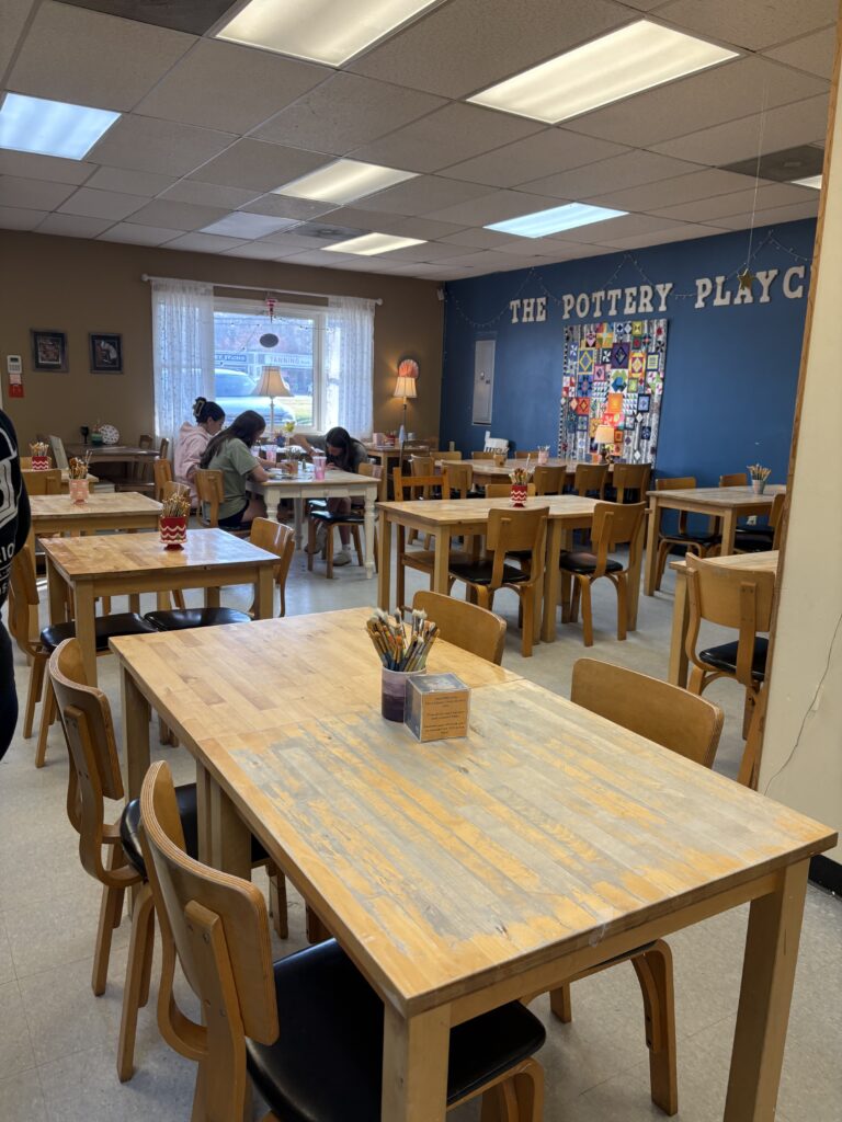 The paint your own pottery studio is shown with the many tables in the painting area.
