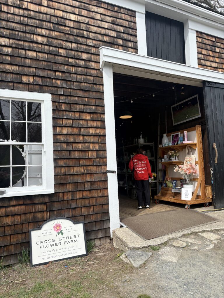 The barn door to the tulip picking farm barn shop is pictured with a sign that reads "Cross Street Flower Farm" out front