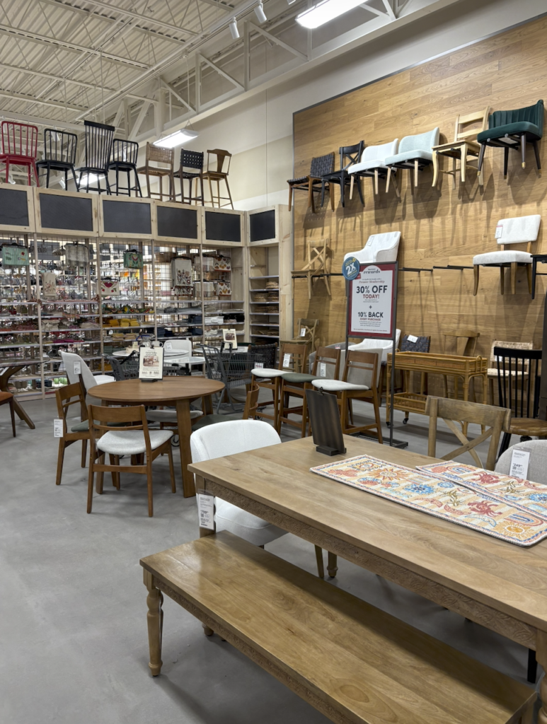 Tables are on display on the sales floor and chairs hang from the hall
