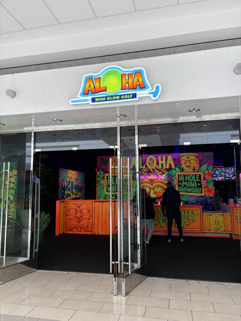 The sign for the indoor Aloha Mini Glow Golf venue