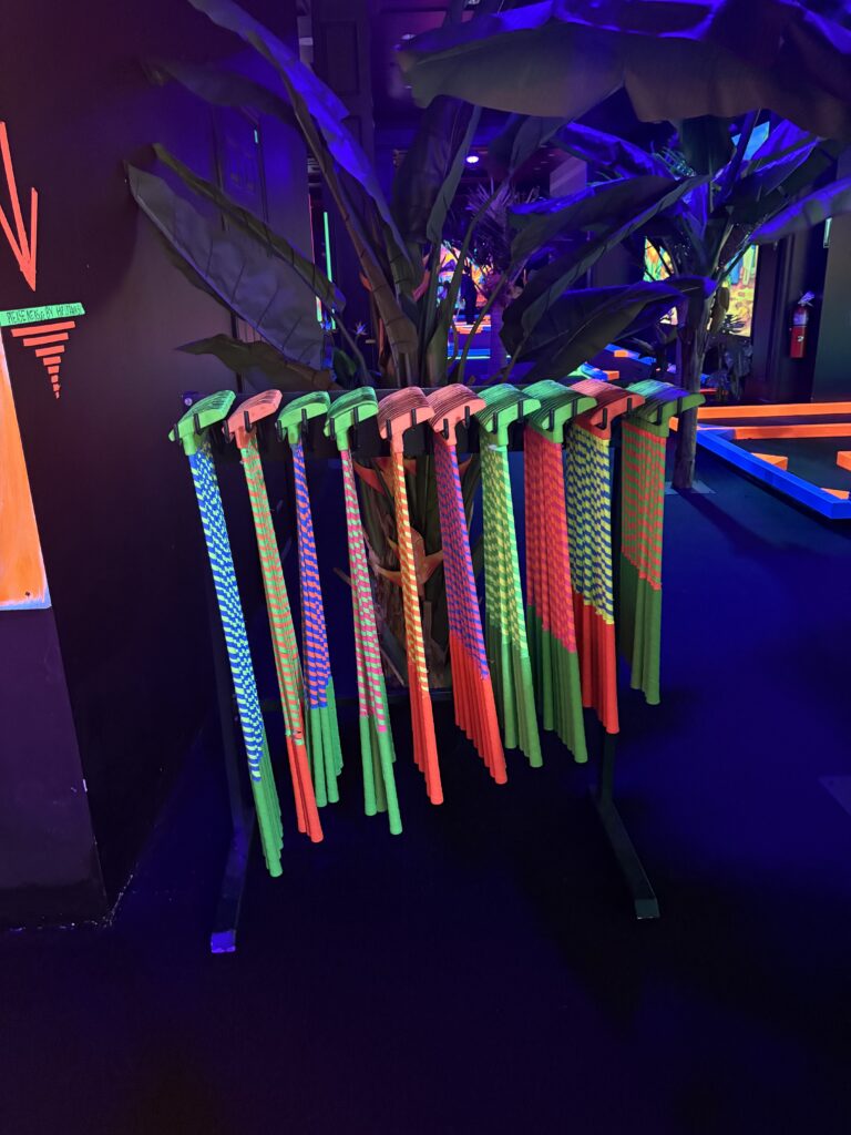 Colorful and striped putters for indoor mini golf are shown 