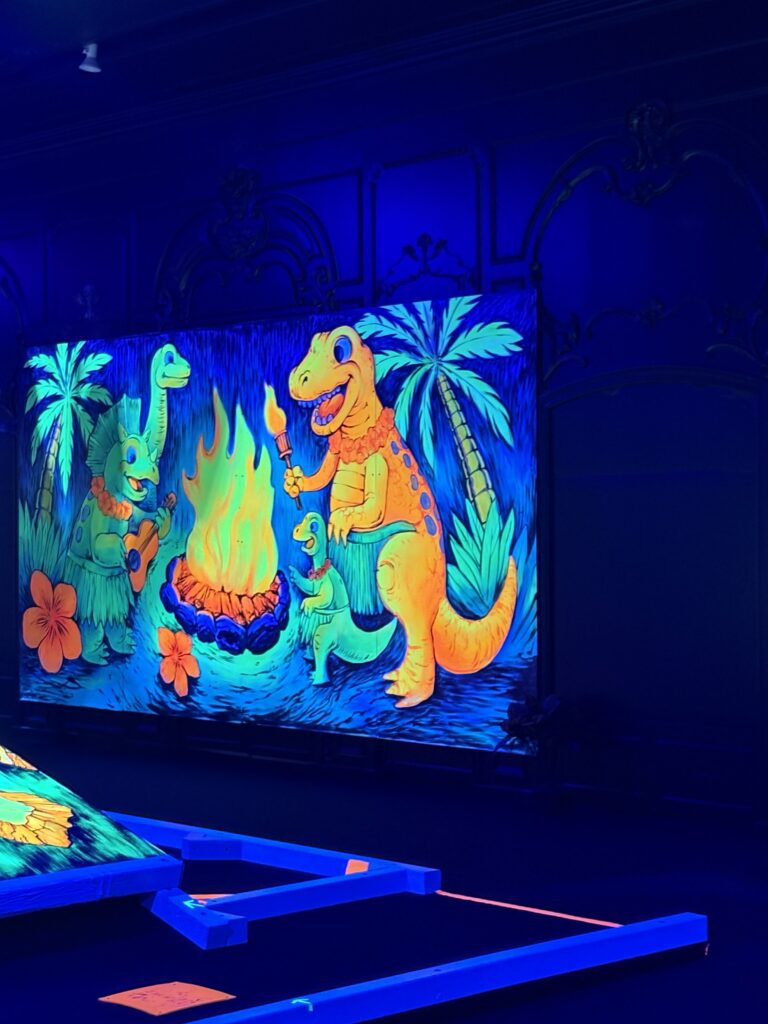 A mural of a group of dinosaurs around a campfire. 