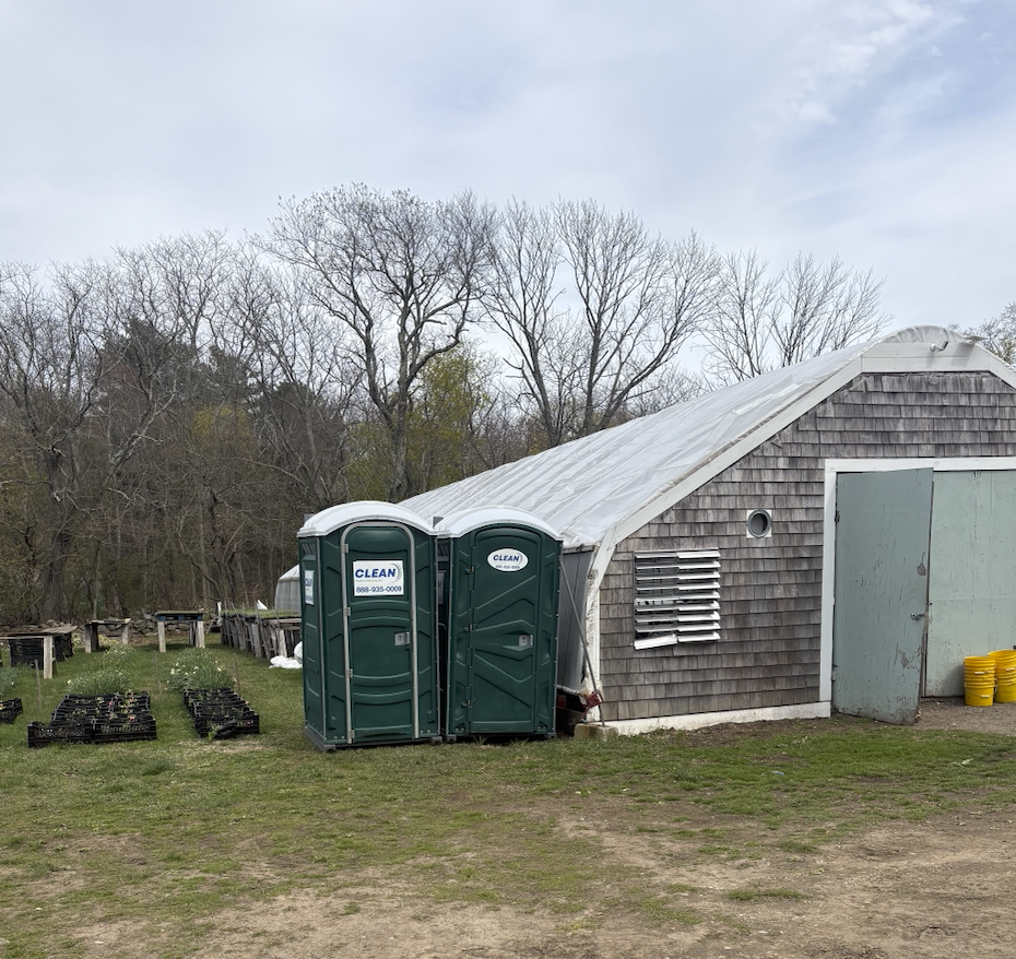 Two green Porta-Pottys are shown