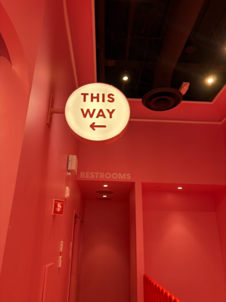 An illuminated sign that says This Way