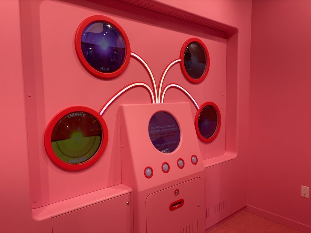A pink interactive exhibit with screens