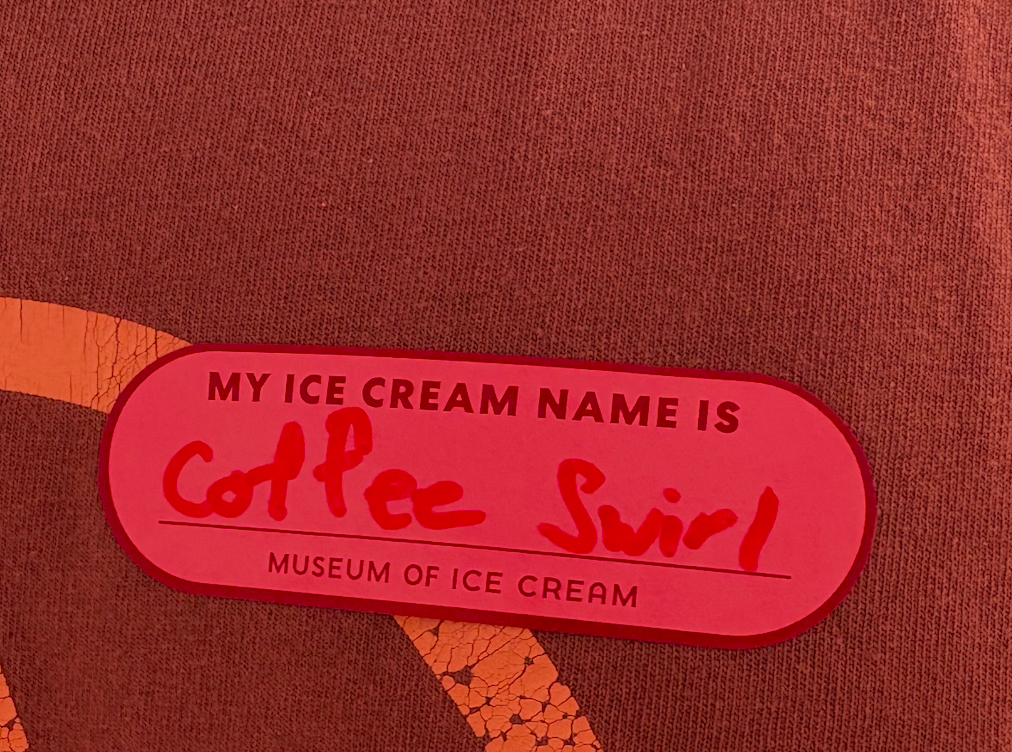 A name tag on a man's shirt that says "Coffee Swirl"